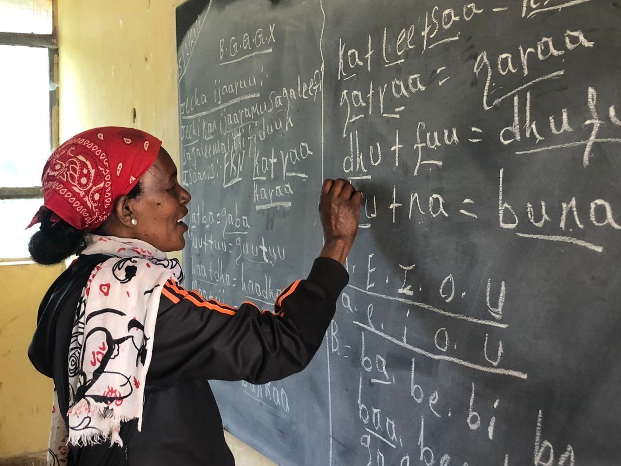 Student writing math on a classroom chalkboard