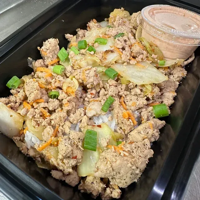 A tray of food with a cup of dipping sauce on the side
