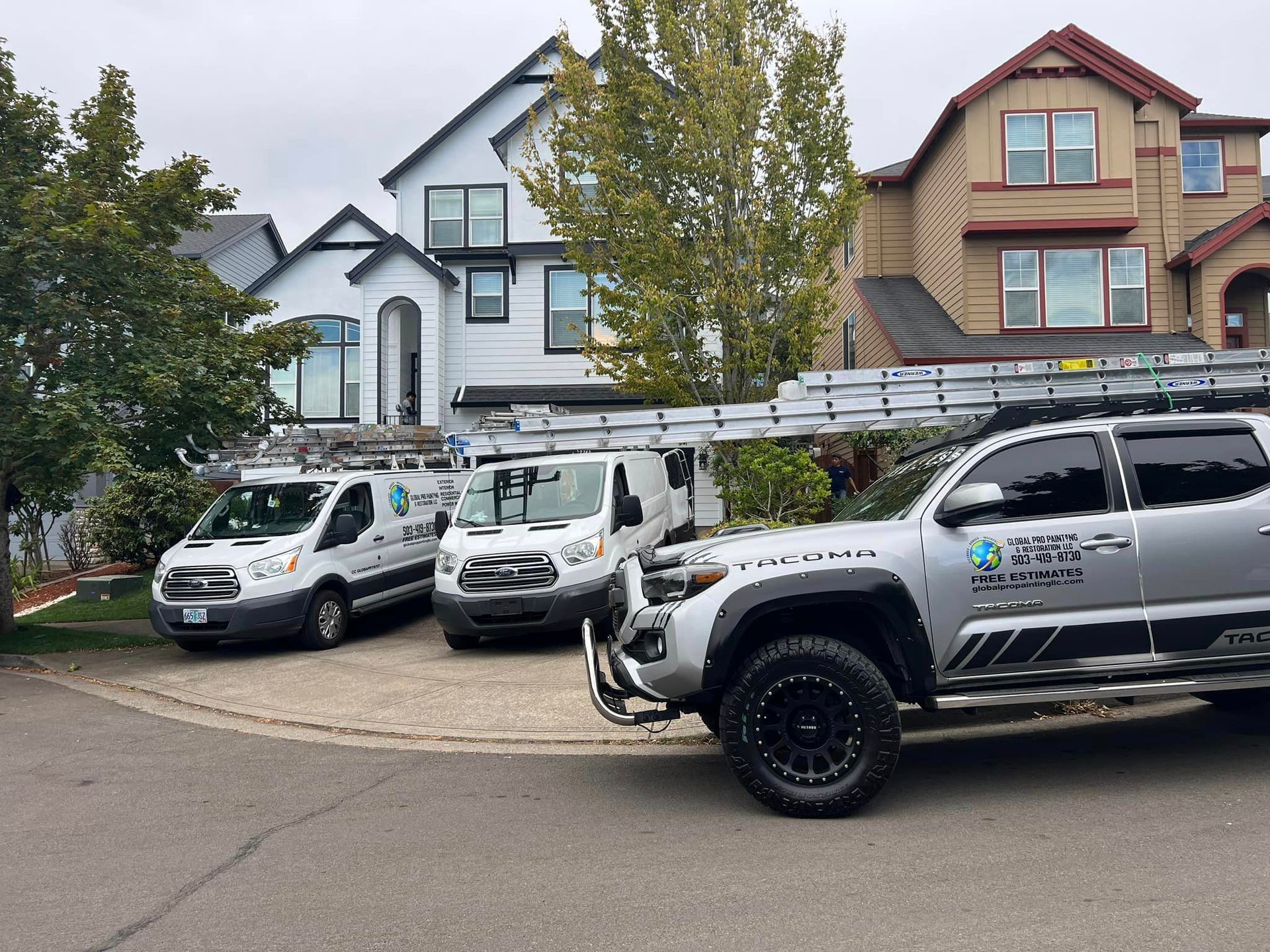 A row of trucks parked in front of a house.