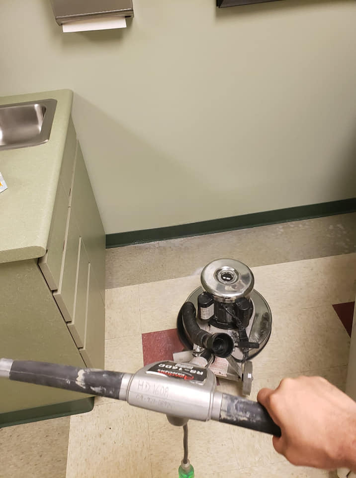 DAG personnel is using a vacuum cleaner in a bathroom