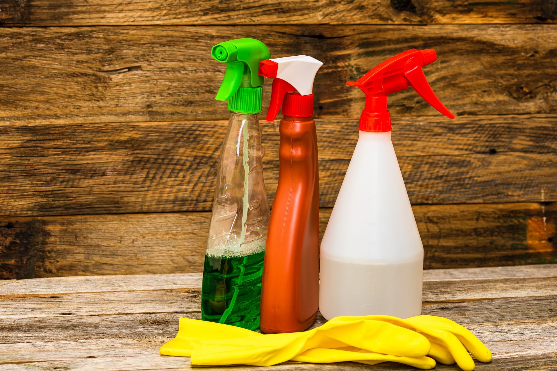 close-up spray bottles with gloves on the table