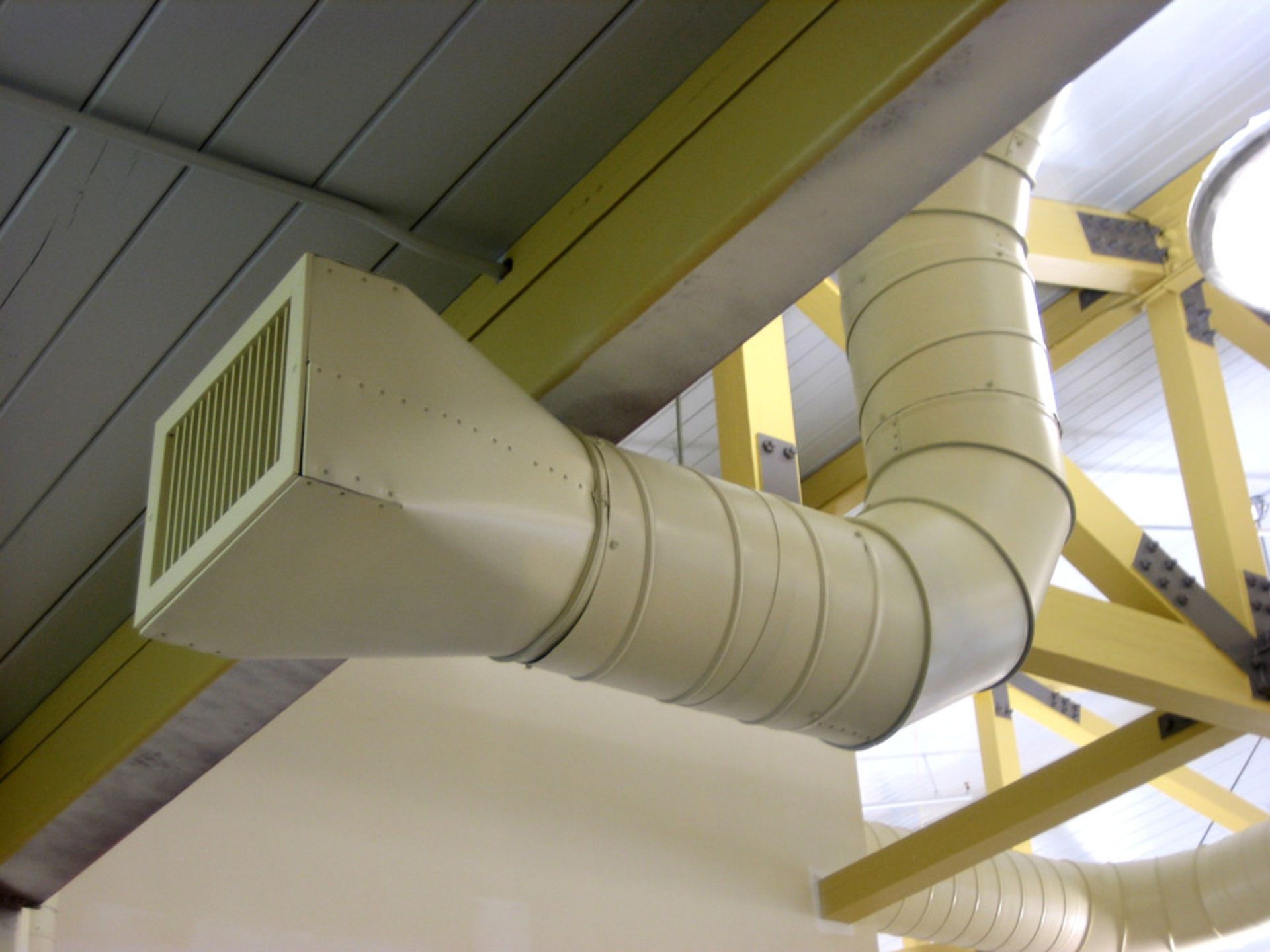 A ventilation pipe is hanging from the ceiling of a building