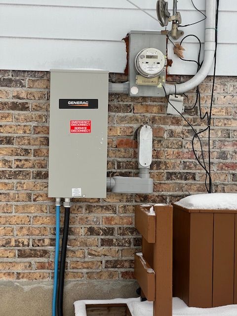 Snowy outdoor utility meters and electrical panels on a brick wall