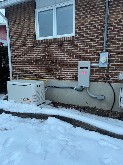 Snowy brick house exterior with utility boxes and an electrical meter on the wall