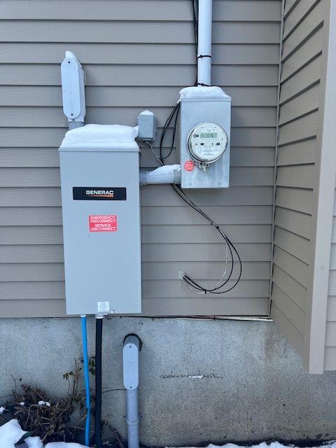 Outdoor electric meters and utility boxes mounted on a house exterior wall.