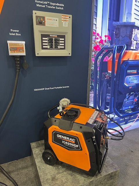 Orange portable welder/generator on display beside a wall-mounted control panel in an industrial setting
