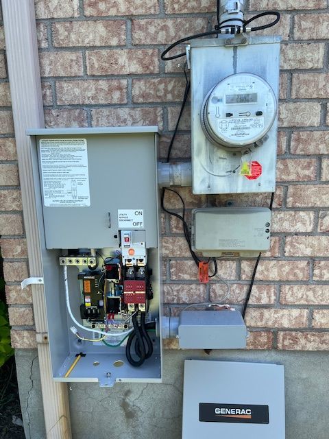 Open electrical meter and service panels mounted on a brick wall