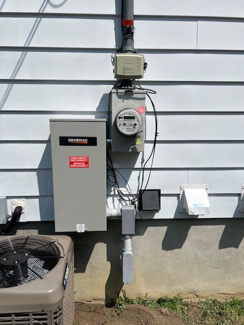 Outdoor gas meter and electrical boxes mounted on a house exterior wall.