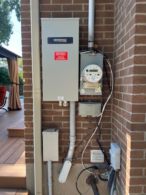 Outdoor electrical meter and breaker panel mounted on a brick wall near a porch