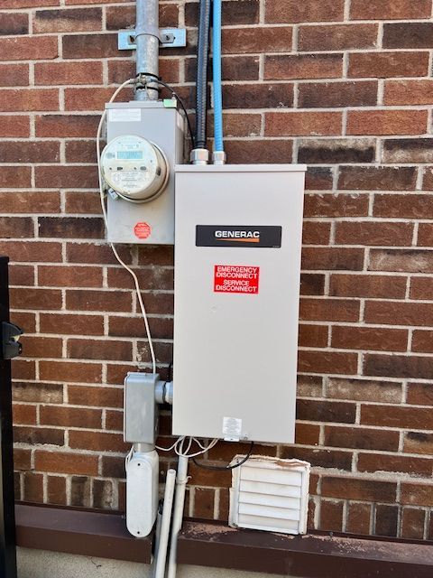 Electrical meter and breaker panel mounted on a brick wall outdoors