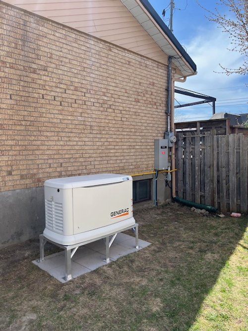 A generator is sitting in the backyard of a brick house.