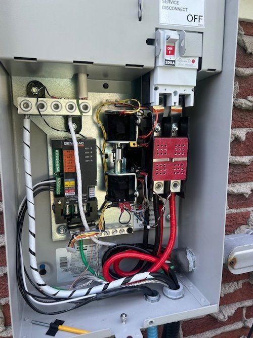 The inside of a electrical box with a lot of wires coming out of it.