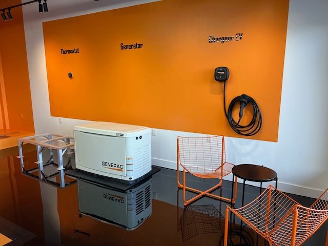 Orange-wall lounge with white appliance, chairs, stool, and coiled cable on the wall