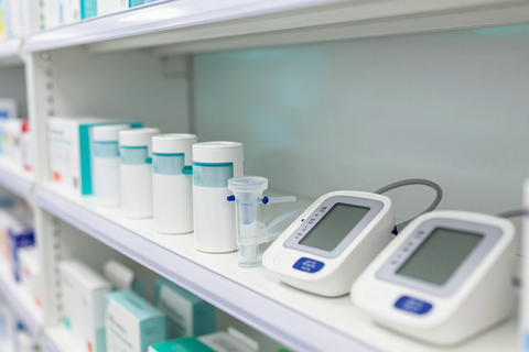 Diversos suministros de laboratorio y medidores digitales dispuestos en un estante blanco en un entorno clínico.