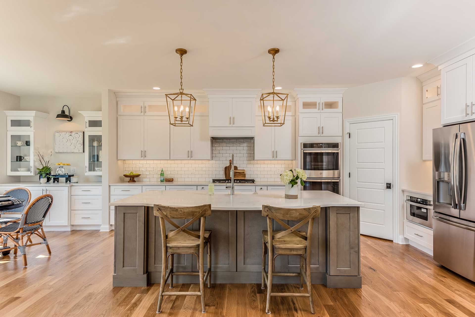 a kitchen with white cabinets and stainless steel appliances and a large island .