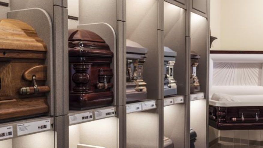 a row of coffins are lined up on shelves in a room .