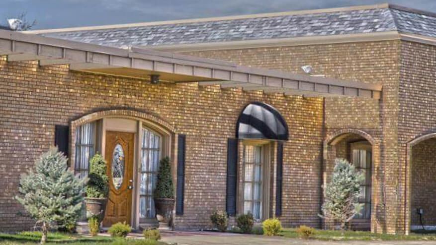 a large brick house with arched windows and a roof .