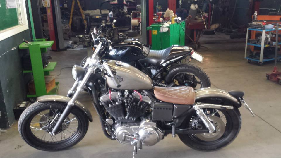 Due motociclette, una argentata e una nera, parcheggiate all'interno di un garage.