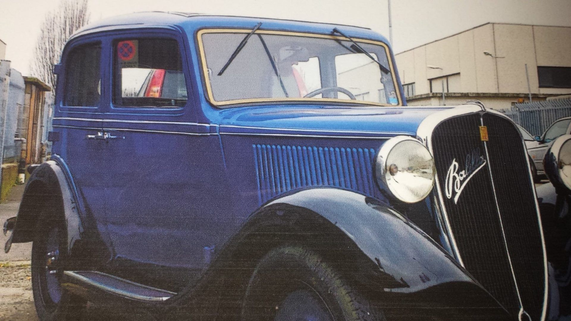 Un'auto d'epoca blu parcheggiata fuori.