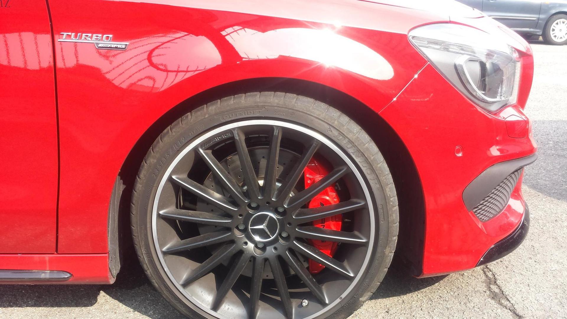 Pneumatico anteriore e cerchione rossi di un'auto Mercedes-Benz, con cerchi neri, pinze dei freni rosse e stemma turbo.
