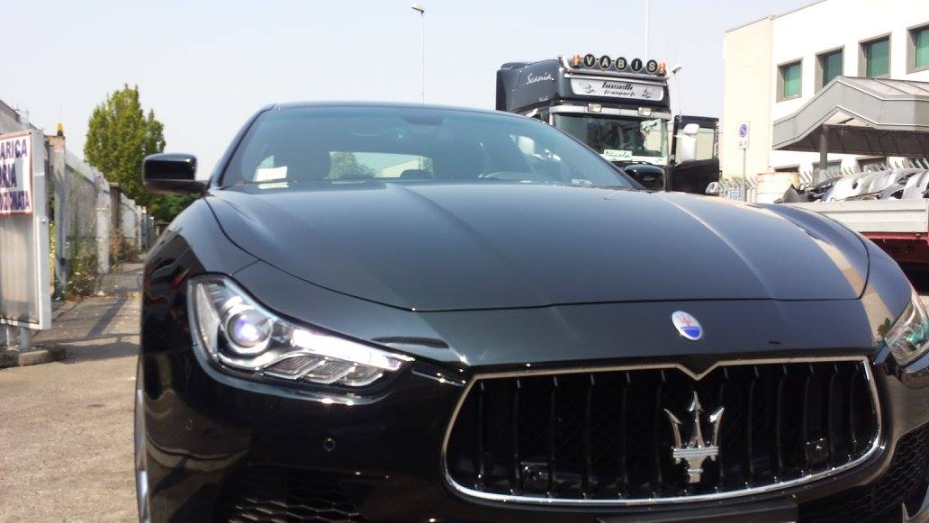 Maserati Ghibli nera parcheggiata all'aperto, vista frontale, con il logo Maserati visibile sulla griglia.