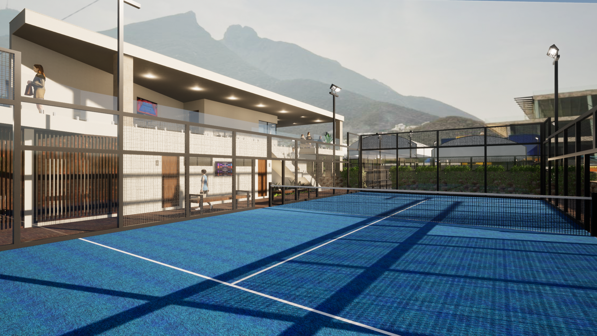 Pista deportiva azul al aire libre con montañas y edificios al fondo.