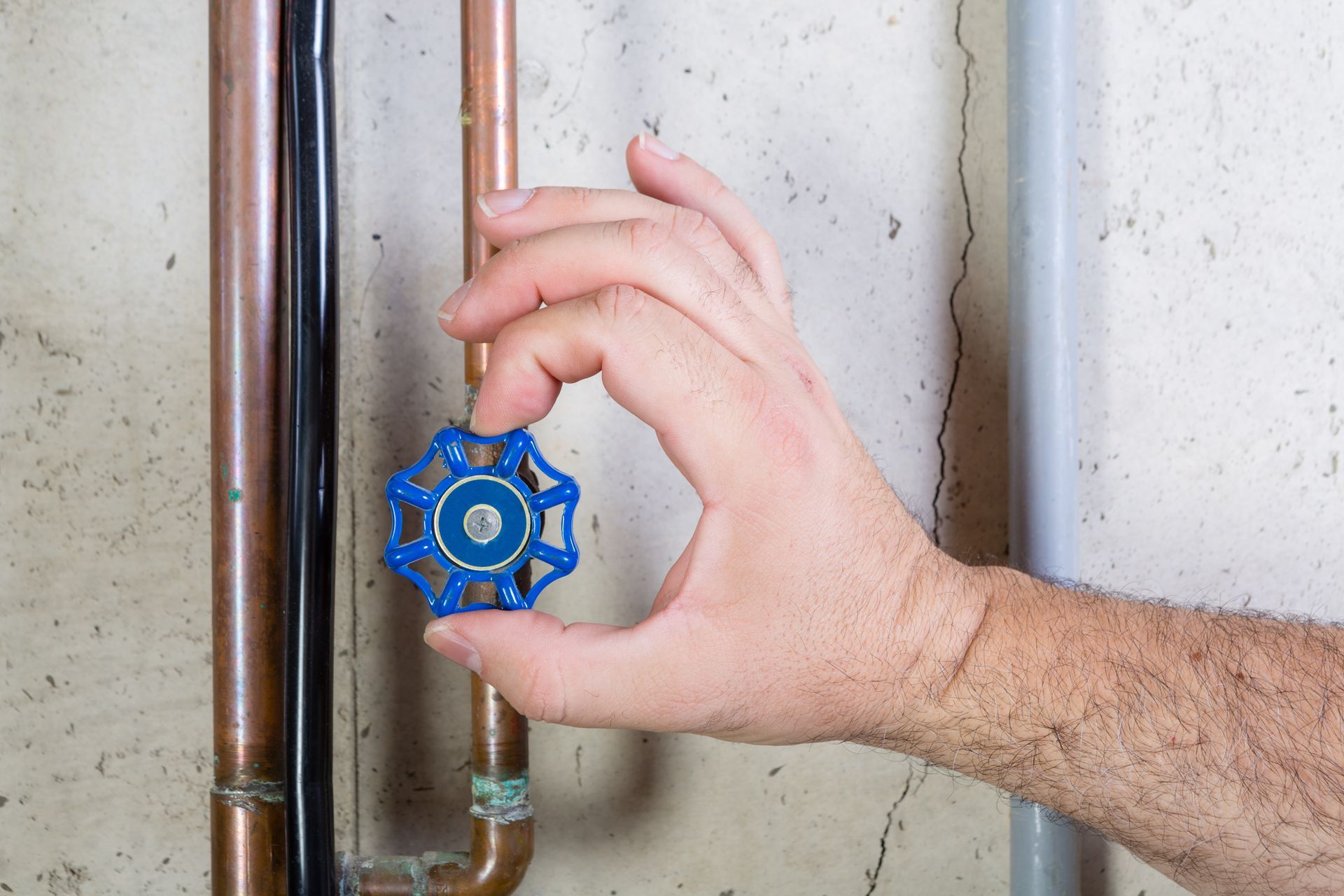 Man shutting off main water valve.