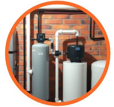 Water softening system with tanks, pipes, and control unit, set against a brick wall.