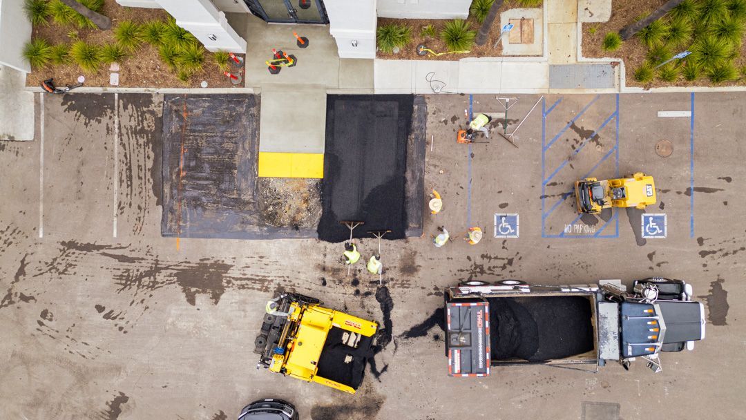 An aerial view of a parking lot being paved.