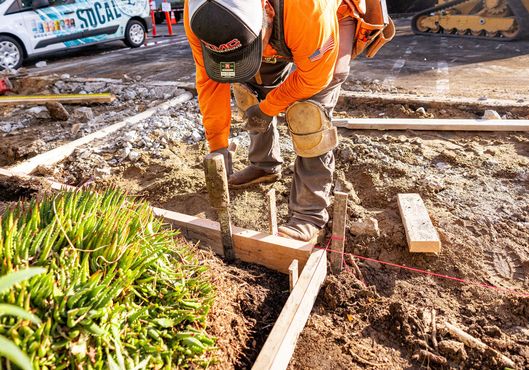 A construction worker is working on a concrete driveway.