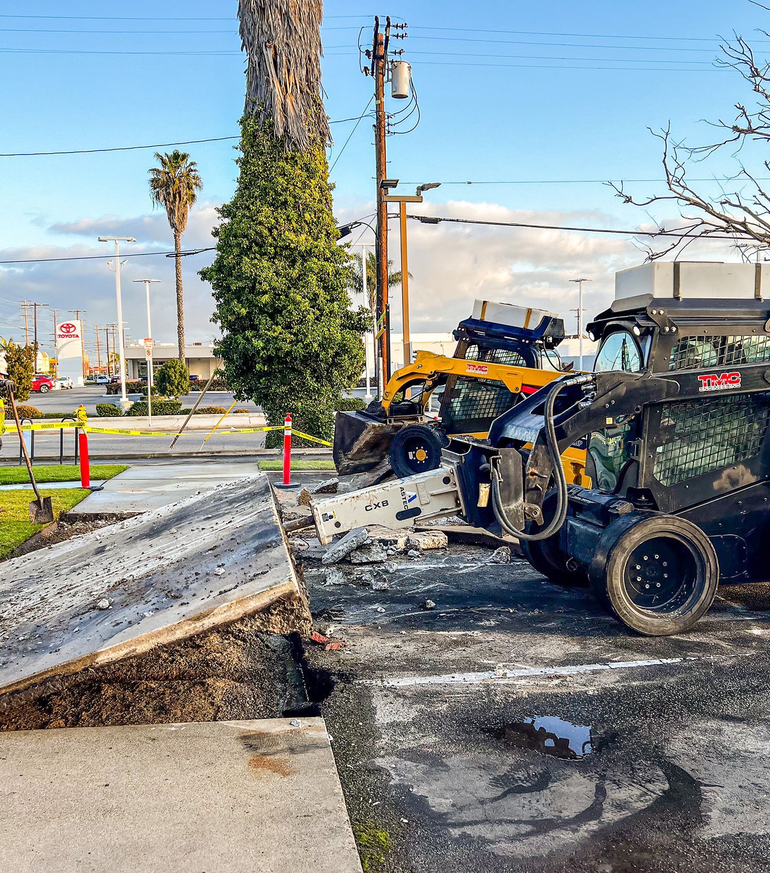 A group of construction vehicles are parked on the side of the road.