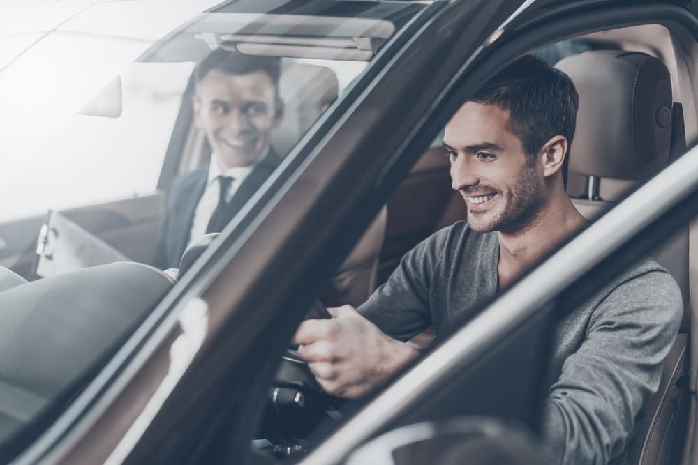 A Man Is Sitting In A Car With A Man Checking His Car Health — Banora Automotive In Tweed Heads South, NSW