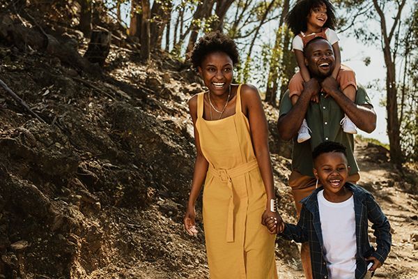 A family is walking down a path in the woods.