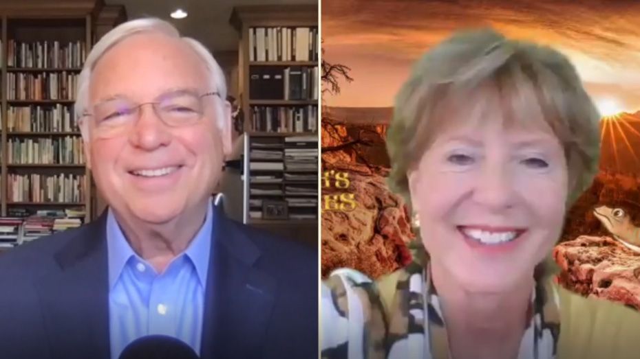 A man and a woman are smiling in front of a bookshelf.