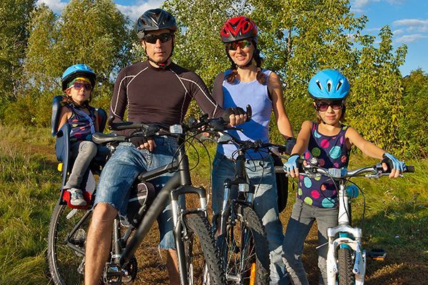 A family is posing for a picture while riding bicycles.