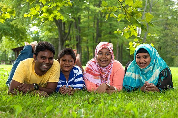 A family is laying on the grass in a park.