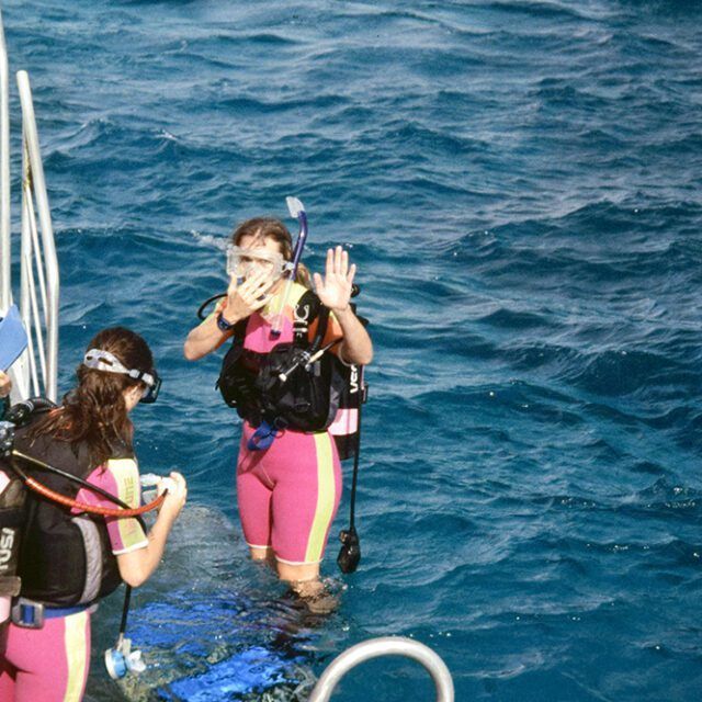 Two female scuba divers are standing in the ocean