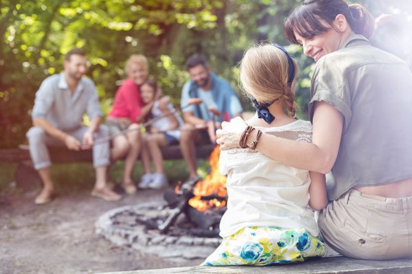 A group of people are sitting around a campfire.