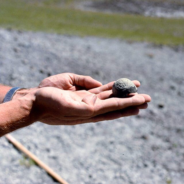 A person is holding a small rock in their hand