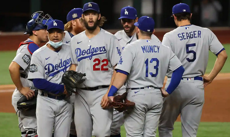 a group of LA Dodgers baseball players are standing on a field .