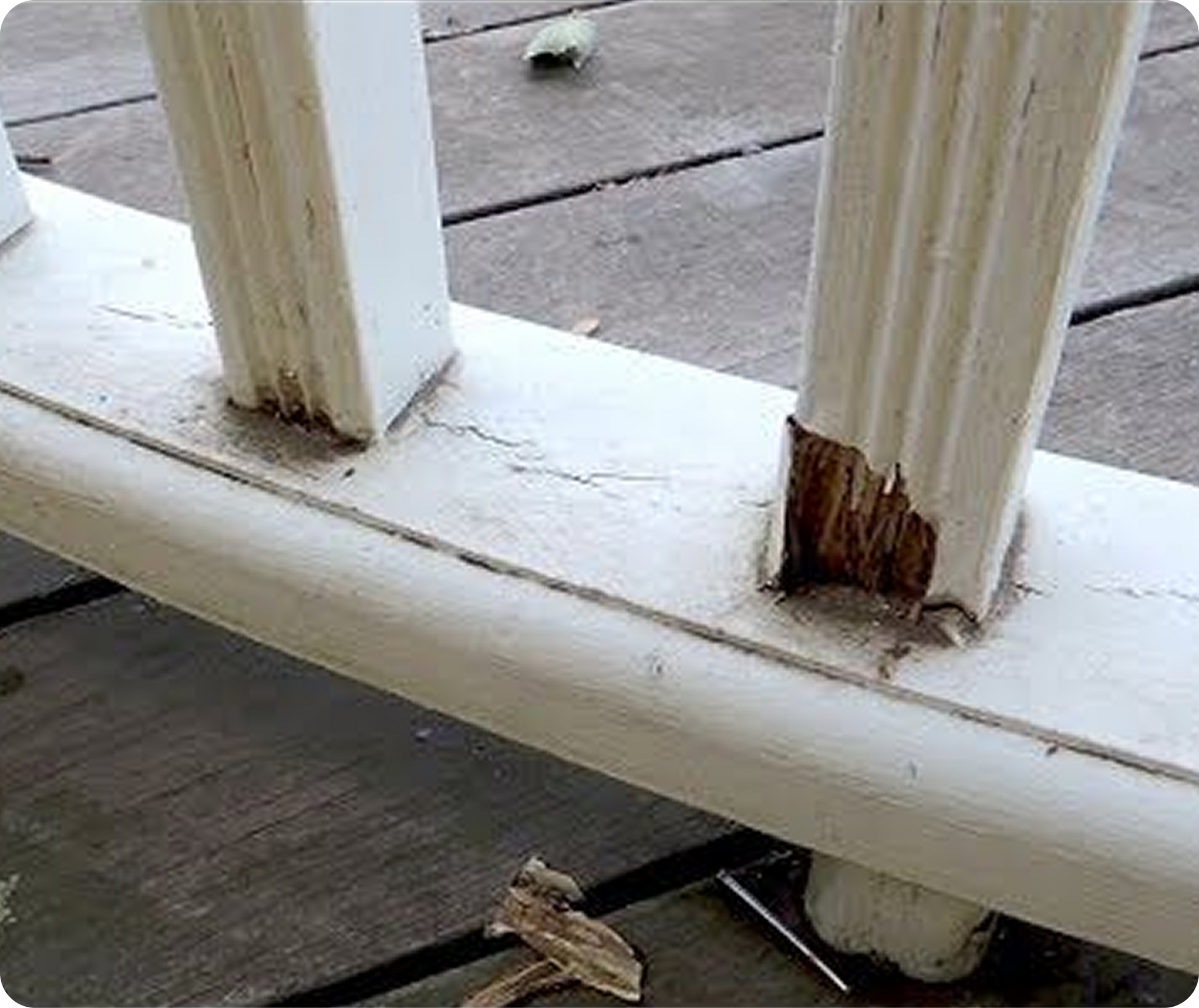 Person smoothing wet concrete on a sidewalk beside a stone wall and house foundation