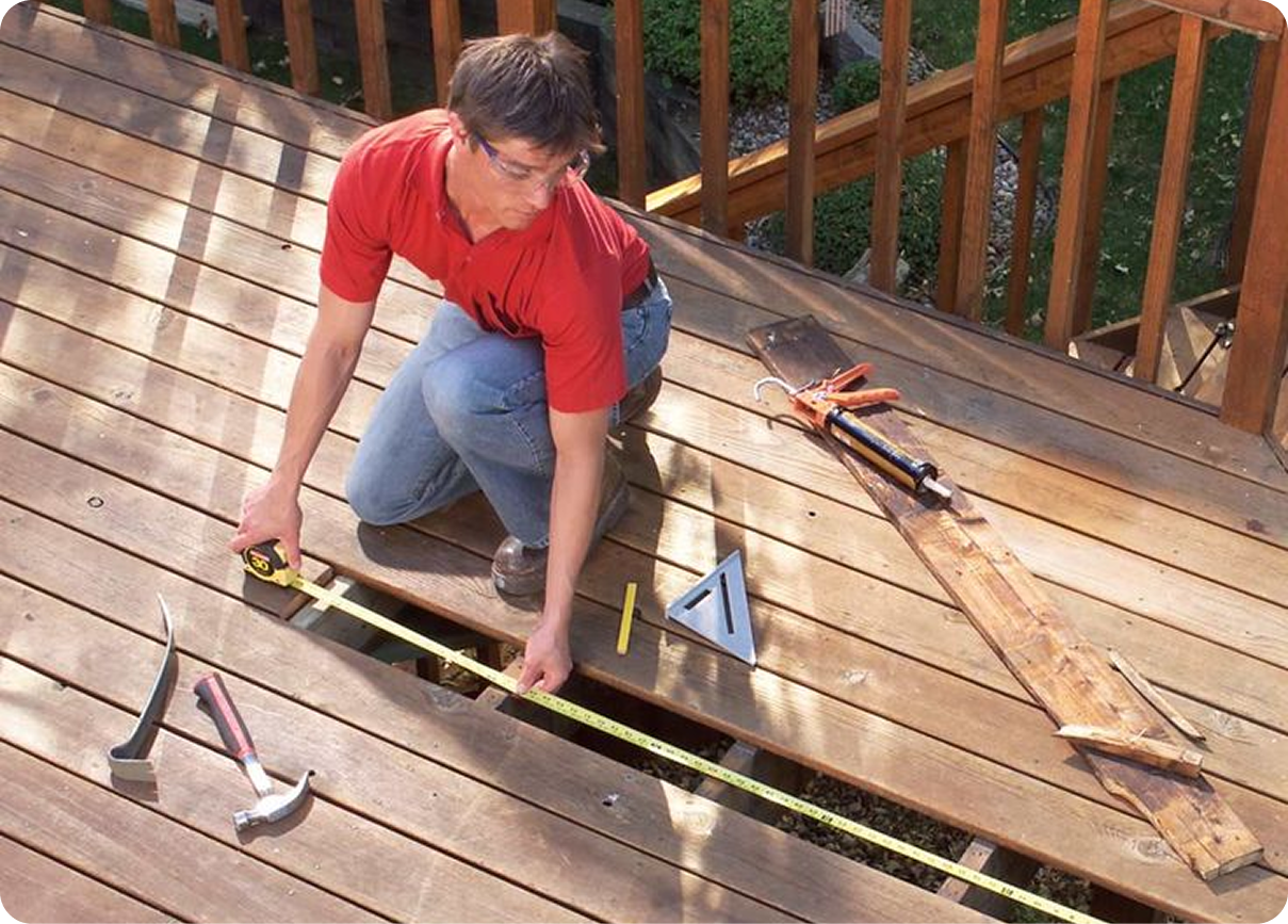 Caulking gun applying white sealant along a window frame beside a hand