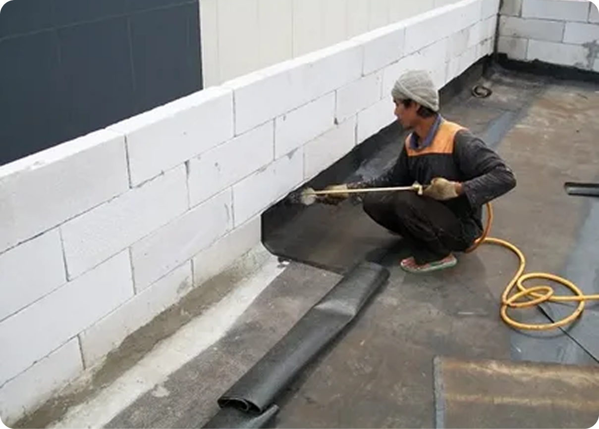 Caulking gun applying white sealant along a window frame beside a hand