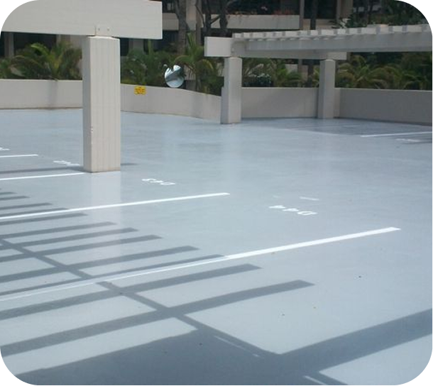 Empty rooftop terrace with a light blue floor and shadow patterns from railings and columns