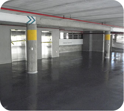 Empty parking garage with concrete pillars and glossy dark floor.