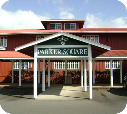 Parker Square building entrance with white columns and red siding under a partly cloudy sky