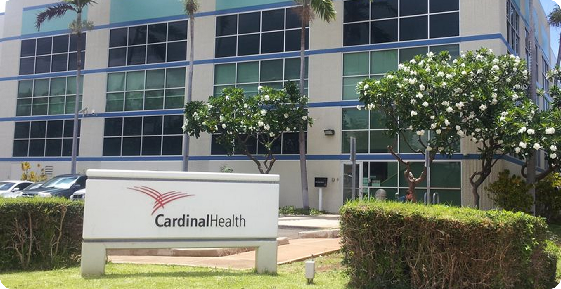 Cardinal Health office building exterior with sign, trees, and landscaped hedges
