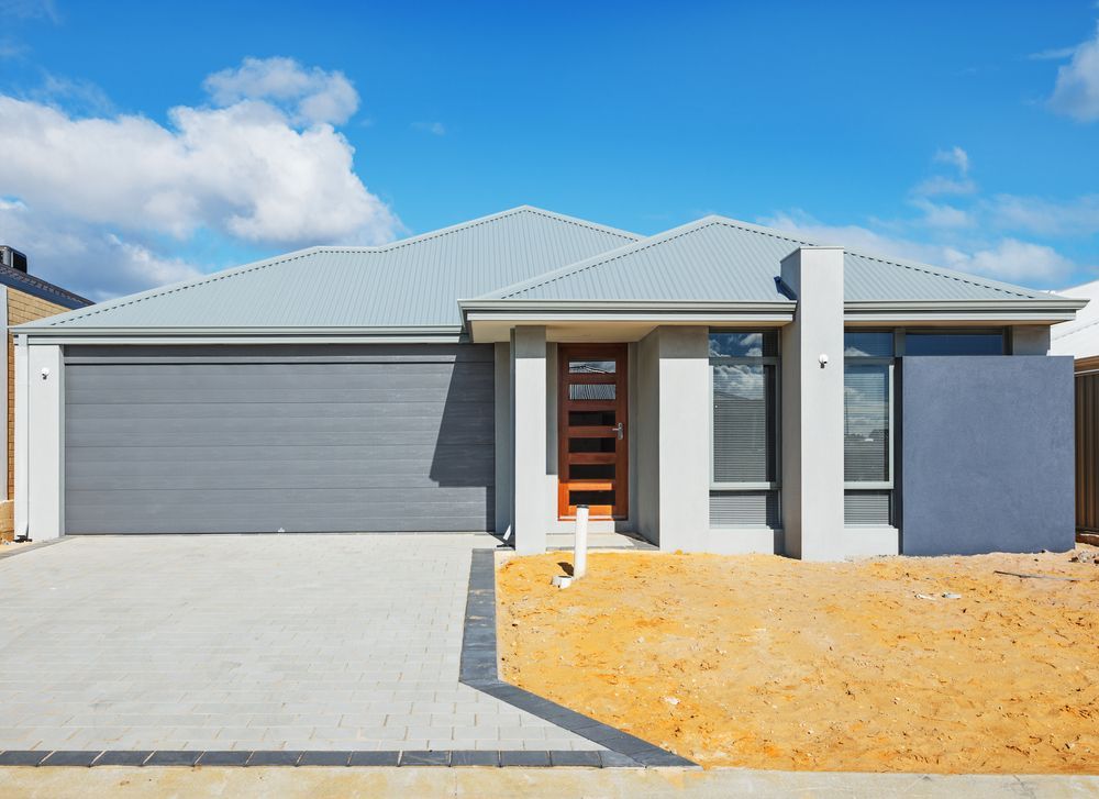 Modern single-story house with gray garage, front entry, and sandy front yard under blue sky - Harris Design & Building Concepts In Jubilee Pocket, QLD