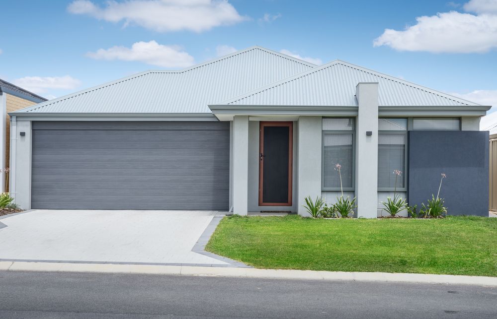 Modern single-story house with gray garage door, front lawn, and driveway under a bright sky - Harris Design & Building Concepts In Jubilee Pocket, QLD