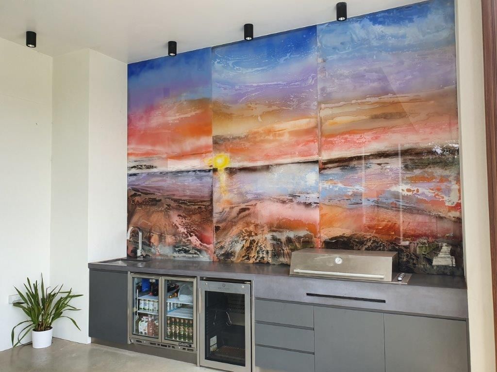 A kitchen with a large painting on the wall.